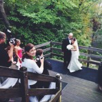 A bride and groom are taking pictures on a bridge