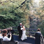 A bride and groom standing on a bridge
