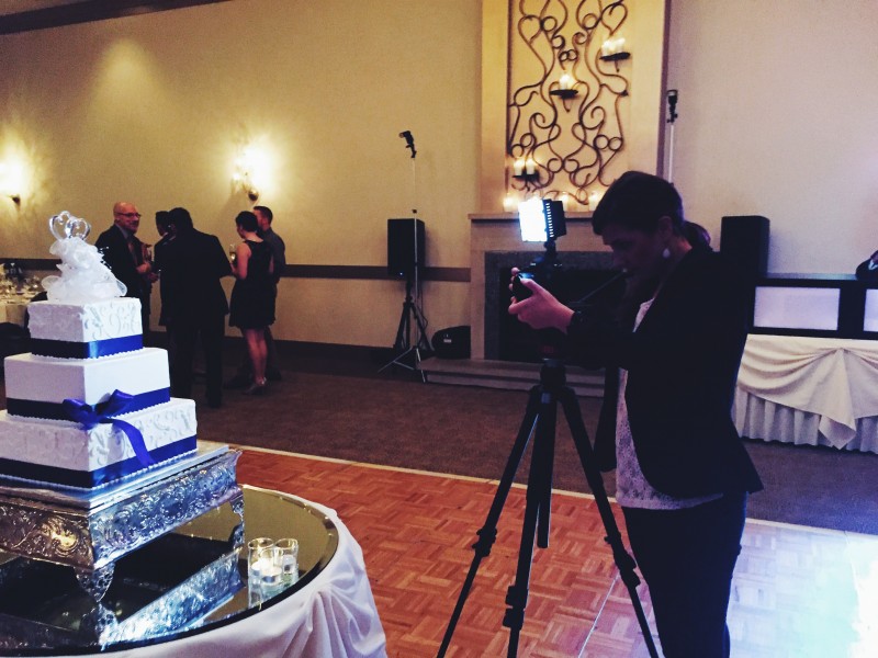 A woman taking a picture of a wedding cake