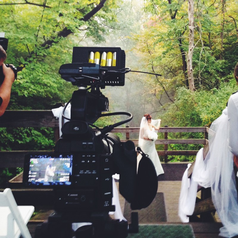 A video camera filming a bride and groom