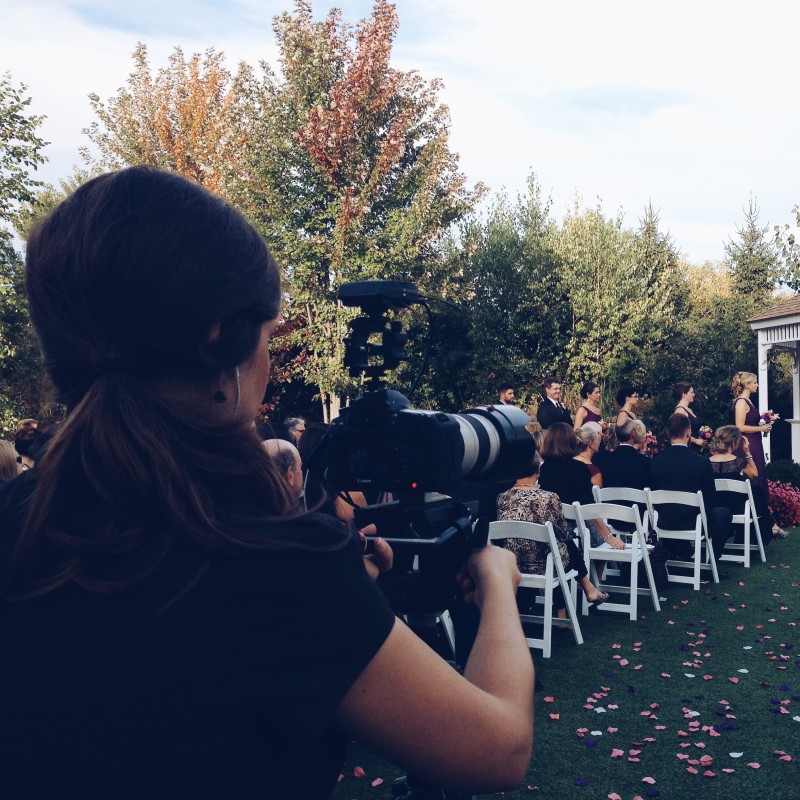 A woman taking a picture of a wedding ceremony