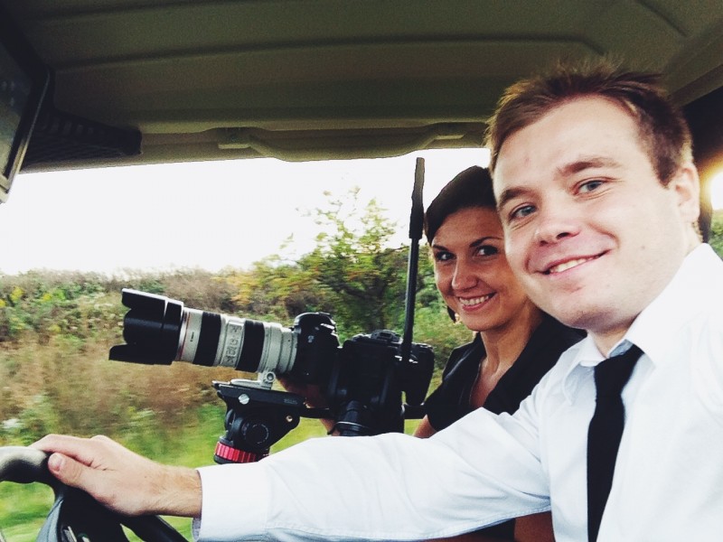 A man and a woman sitting in a vehicle with a camera