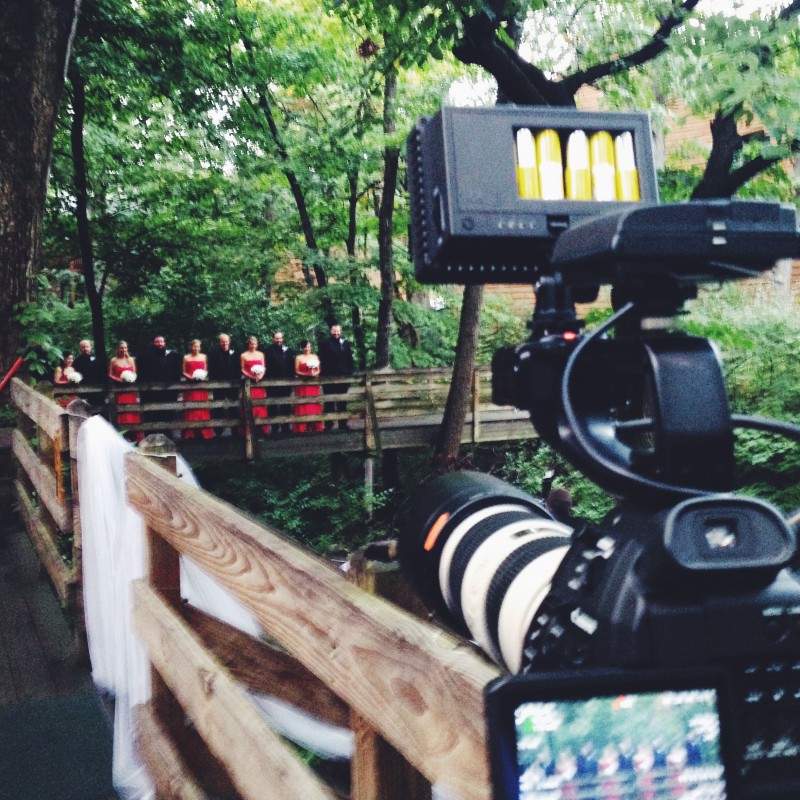 A camera filming a group of people in the woods