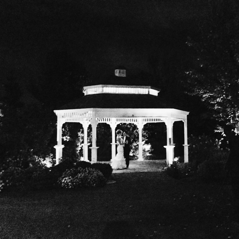 A gazebo lit up at night in a park