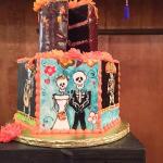 A three tiered cake decorated with skulls and skeletons