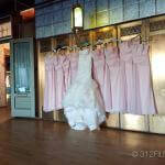 A wedding dress hanging on a rack in a room