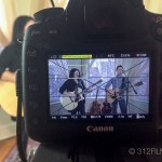 A camera with a picture of two people playing guitar