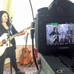 A woman playing a song on a video camera