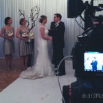 A bride and groom standing in front of a camera