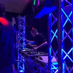 A dj mixing music at a party in a dark room