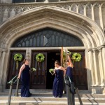 A group of women in blue dresses standing outside of a church