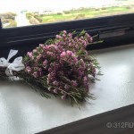 A bouquet of flowers sitting on top of a window sill