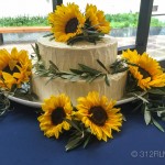 A three layer cake with sunflowers on a table