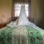 A woman in a wedding dress standing on a bed