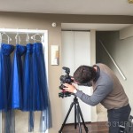 A man taking a picture of a dress hanging on a rack