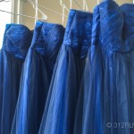 A group of blue dresses hanging on a rack