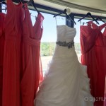 A bride's dress hanging on a rack in front of a window