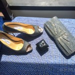 A pair of shoes, a ring, and a purse are sitting on a blue