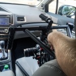 A man sitting in a car with a camera in his hand