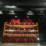 A stage with a red curtain and red seats