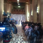 A wedding ceremony is being filmed in a large room