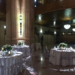 A banquet hall with tables and chairs and chandeliers