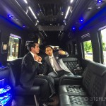 A couple of men sitting in the back of a limo