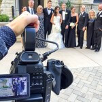 A person taking a picture of a wedding party