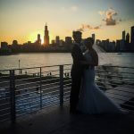 A bride and groom pose for a photo in front of a Chicago city skyline