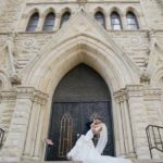 A bride and groom standing in front of a Holy Name Cathedral Chicago church