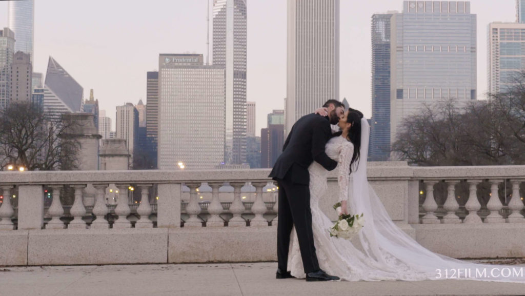 A bride and groom kissing in front of a Chicago city skyline