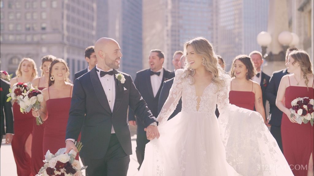 The bridal party with the bride and groom taking pictures by the Wrigley Building in Chicago — one of the best spots in the city!