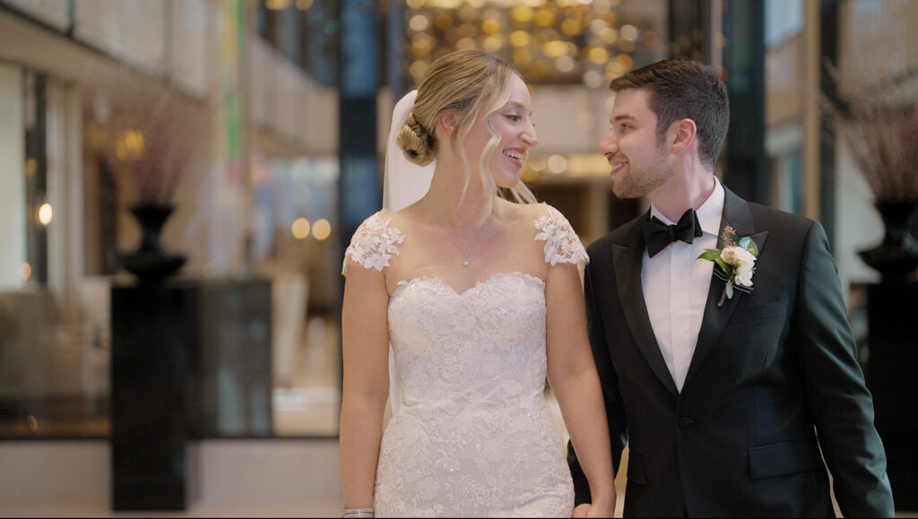 The bride and groom smile at each other in the Langham Hotel in Chicago.