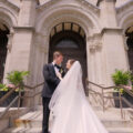 A bride and groom standing on the steps of St Clement church Chicago