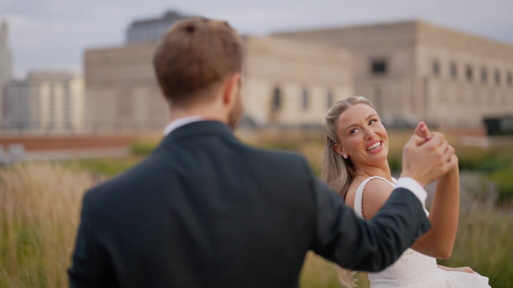 The bride and groom are dancing on the rooftop of The Meadow at the Old Post Office (TOPO) during the golden hour.