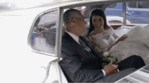 The bride and her father pose in front of an old Rolls-Royce in Chicago before the wedding.