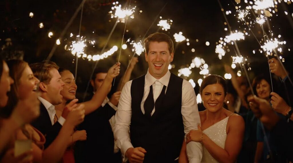 The bride and groom are surrounded by their guests during the sparkler exit.