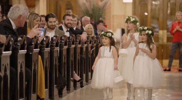 The flower girls walk down the aisle.