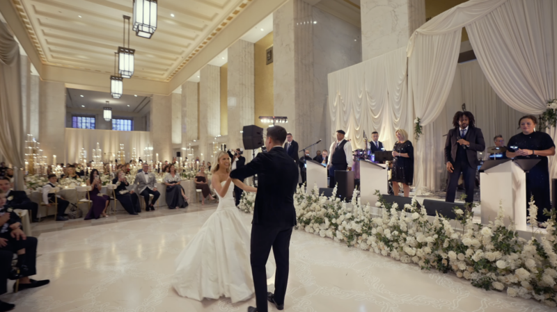 A couple are dancing at the Old Post Office while a band is playing in the background.