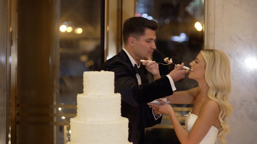 A couple receives a piece of cake made by Alliance Bakery for their wedding at TOPO.