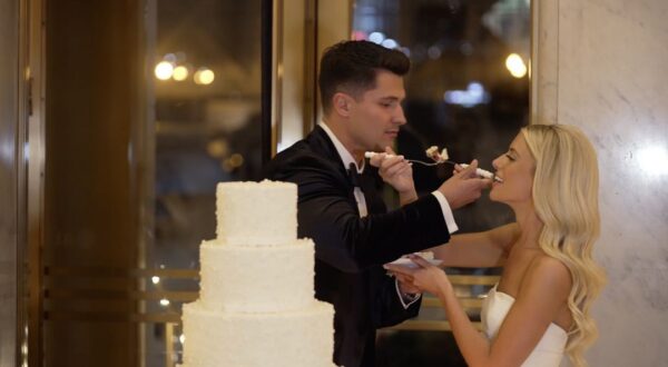 A couple receives a piece of cake made by Alliance Bakery for their wedding at TOPO.
