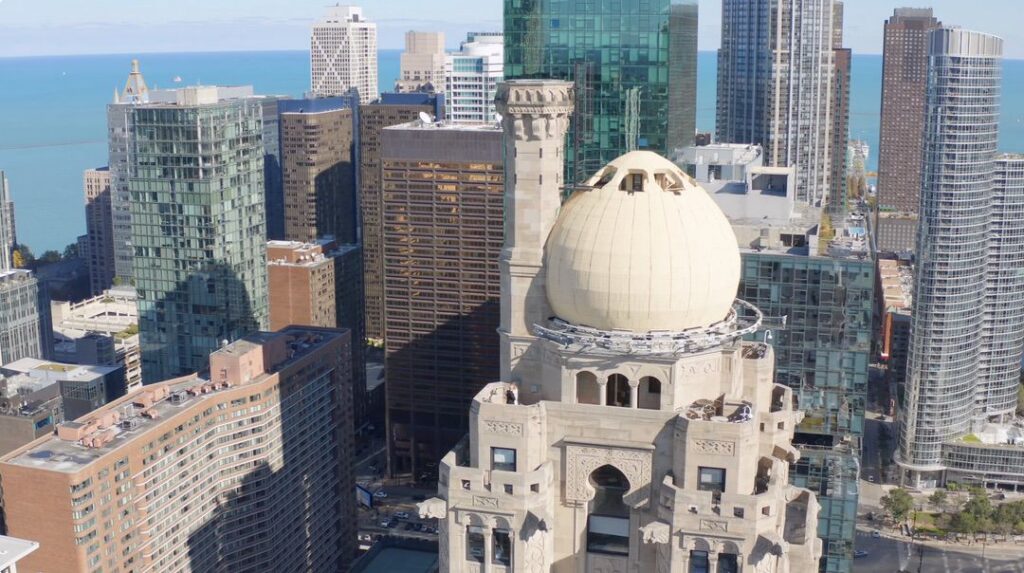 Drone shot of the InterContinental Chicago with a couple standing at the top during their first look.