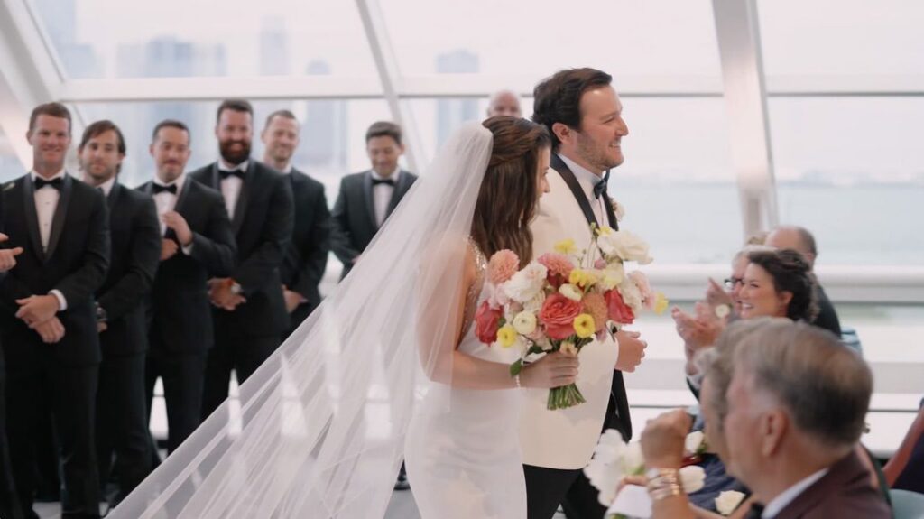The bride and groom recess at their wedding at the Adler Planetarium in Chicago, surrounded by flowers from Life in Bloom.
