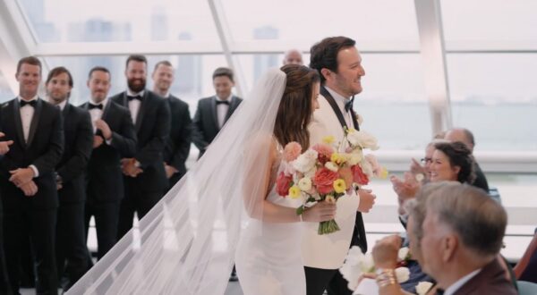 The bride and groom recess at their wedding at the Adler Planetarium in Chicago, surrounded by flowers from Life in Bloom.