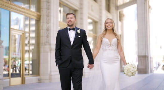 A bride and groom holding hands and walking down the street in Chicago Wrigley Building