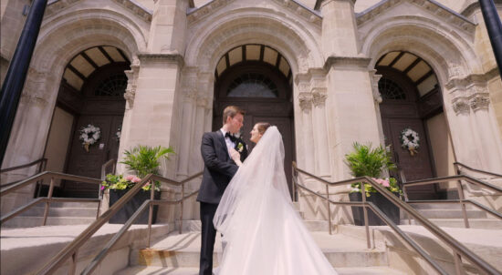 A bride and groom standing on the steps of St Clement church Chicago